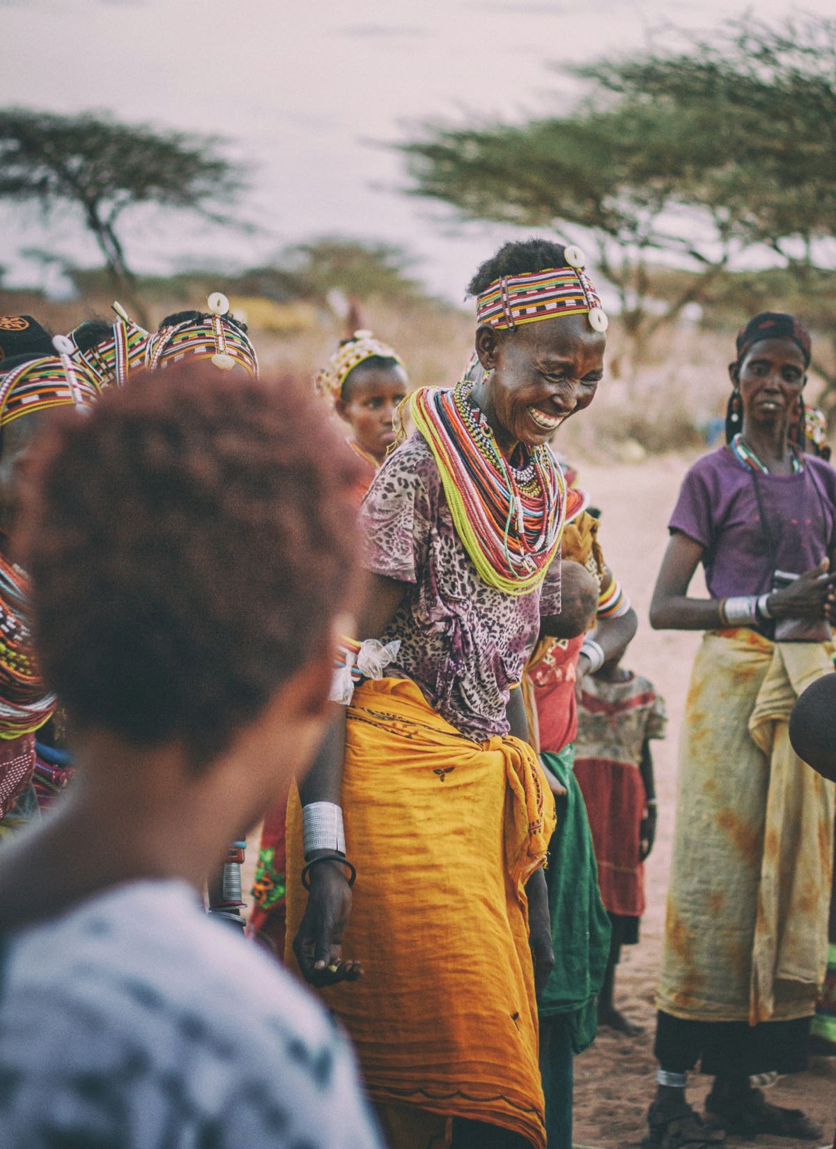 Smiling Samburu woman in traditional beaded necklaces and colourful dress at a village gathering in Kenya