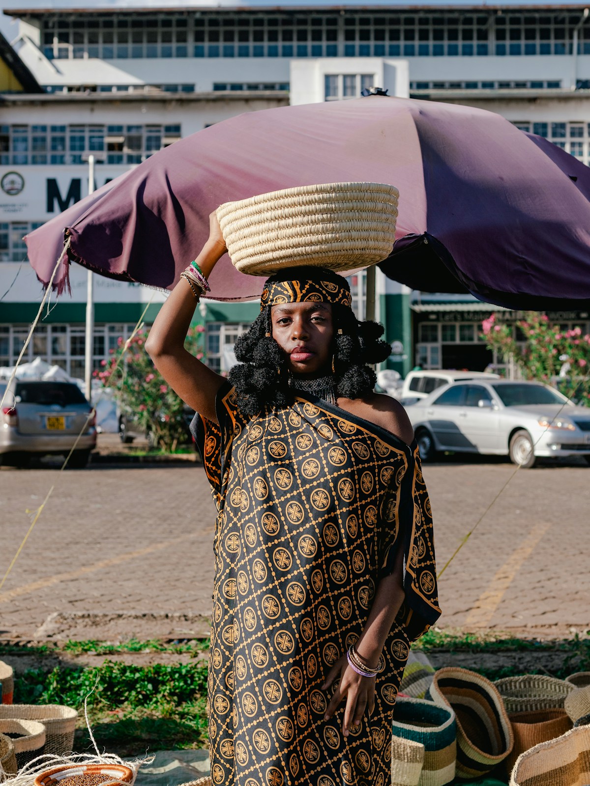 Kenyan woman in traditional dress carrying a woven basket at a market
