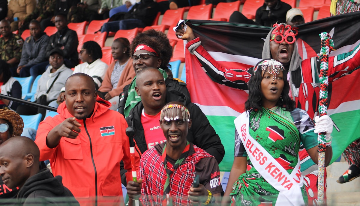 Kenyan fans with national flags celebrating at a sports event in Kenya