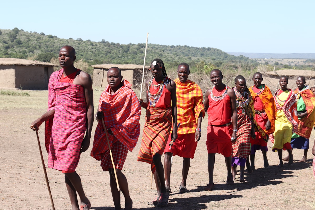 Maasai people in traditional red dress walking on a path in Kenya