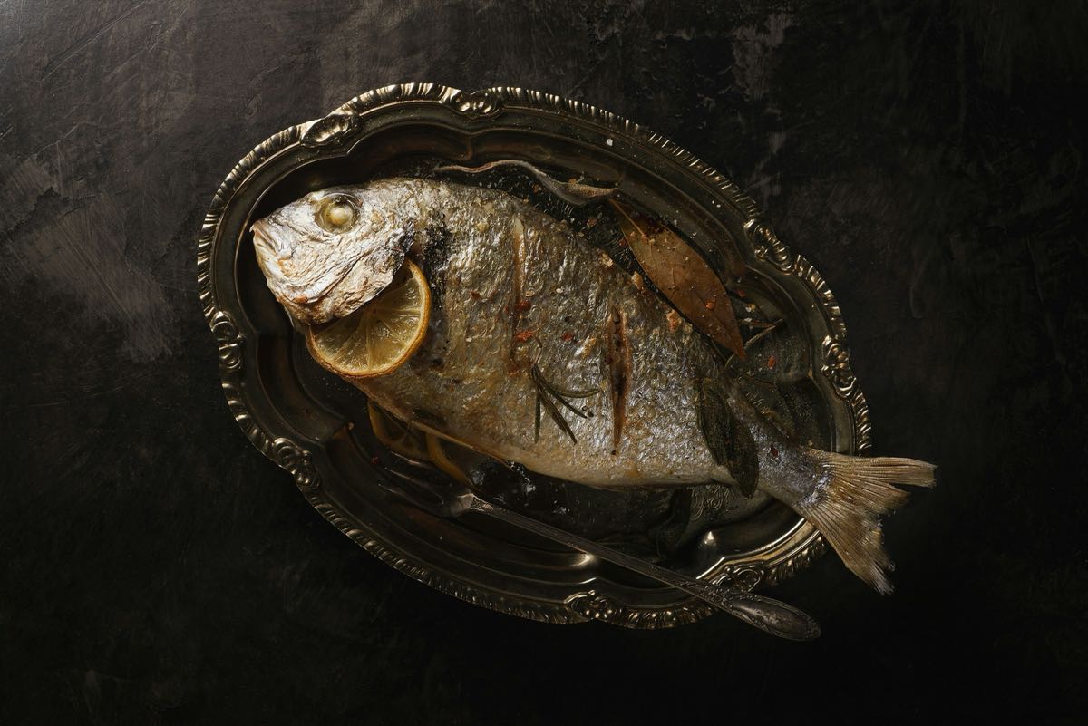 Whole roasted fish on a silver platter, representing the seafood cuisine of the Swahili coast