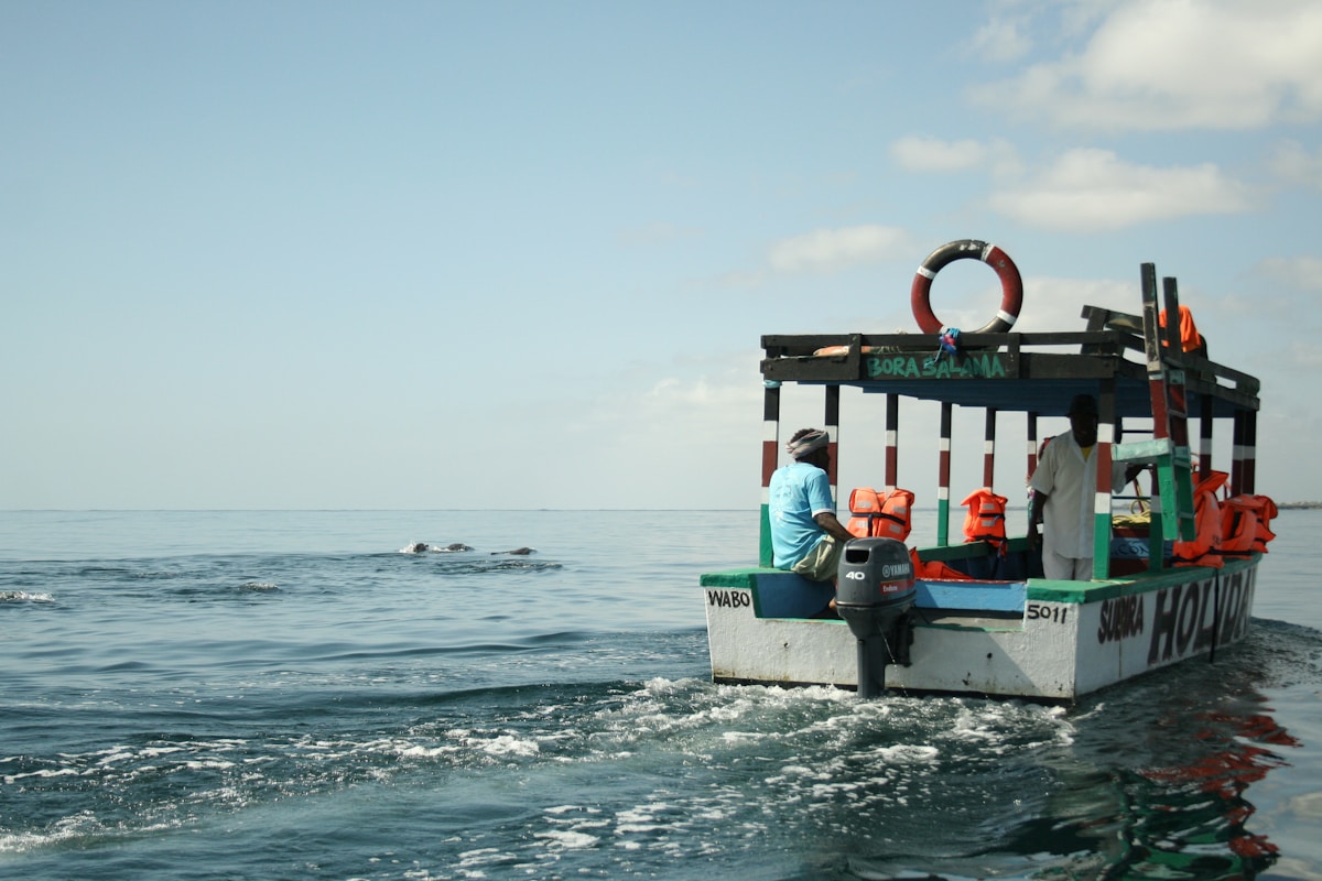A tour boat on the Indian Ocean at Watamu with passengers spotting marine life, Kenya