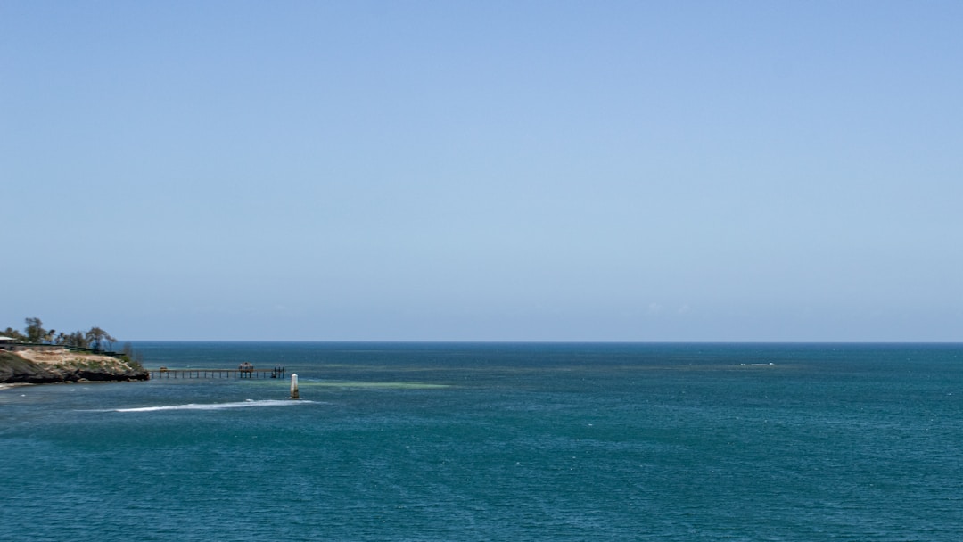 Clear turquoise Indian Ocean water off the Kenya coast with a small jetty
