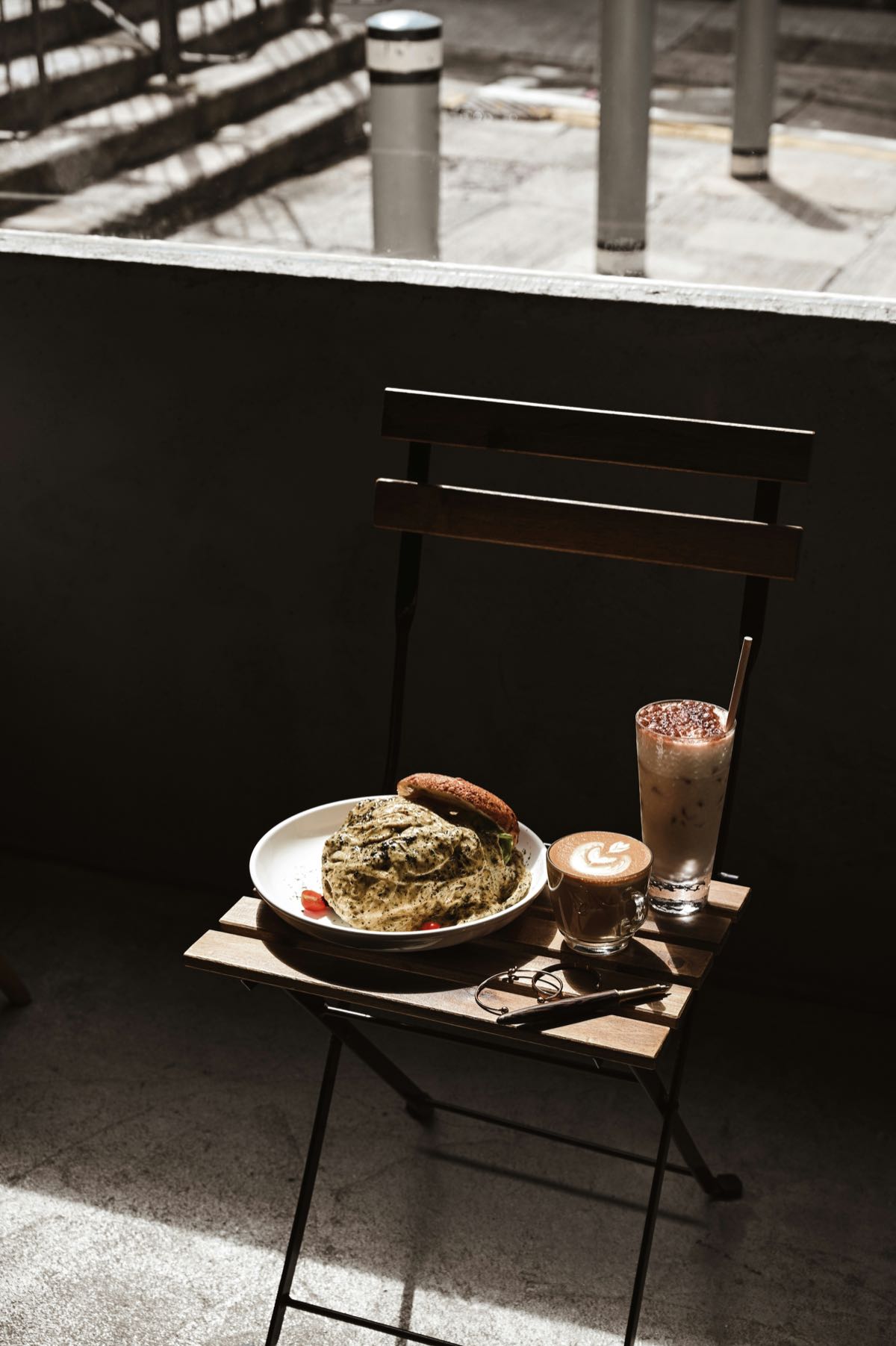Cafe table with a plant-based meal and iced latte, representing Nairobi's café dining scene
